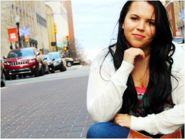 A picture of a female teenager sitting on a city street.