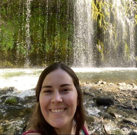 Picture of Ashlyn Crouch near a waterfall smiling.
