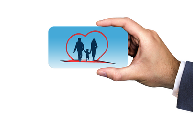 Picture of a male hand holding a picture of a male, female and child silhouette with a heart. 